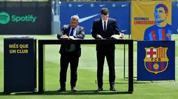 Bek baru Barcelona, Andreas Christensen (kanan) menandatangani kontrak dengan Presiden Barcelona Spanyol Joan Laporta selama upacara presentasinya di tempat latihan Joan Gamper di Sant Joan Despi, dekat Barcelona (7/7/2022). Barcelona telah mengumumkan Christensen sebagai rekrutan anyar mereka di musim panas ini. (AFP/Pau Barrena)