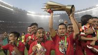 Kapten Persija Jakarta, Ismed Sofyan, mengangkat piala bersama rekan-rekannya usai mengalahkan Mitra Kukar pada laga Liga 1 di SUGBK, Jakarta, Minggu (9/12). Persija menang 2-1 atas Mitra. (Bola.com/Vitalis Yogi Trisna)