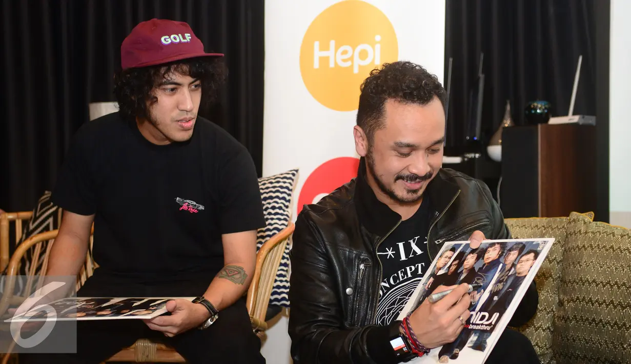 Giring Nidji membubuhkan tanda tangan pada album edisi khusus "Breakthru" versi piringan hitam (vinyl), Jakarta, Senin (28/11). (Liputan6.com/Herman Zakharia)