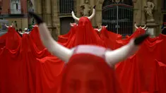Orang-orang menutup diri dengan kain warna merah saat memprotes kekejaman terhadap hewan sebelum dimulainya Festival San Fermin di Alun-Alun Plaza del Ayuntamiento, Pamplona, Spanyol, Rabu (5/7/2023). (AP Photo/Alvaro Barrientos)