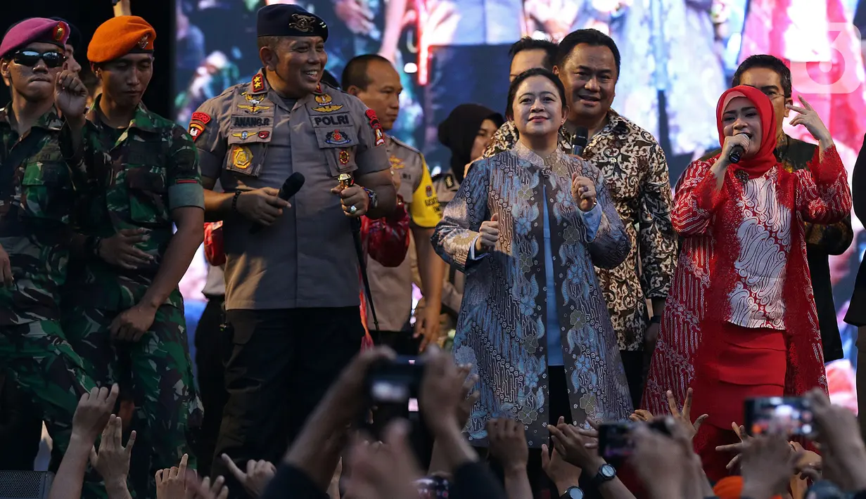 Ketua DPR RI Puan Maharani bernyanyi bersama pedangdut Ikke Nurjanah di atas panggung hiburan dangdut di Lapangan DPR Senayan, Jakarta, Senin (21/10/2019). Acara untuk mengapresiasi aparat keamanan TNI-Polri yang bertugas menjaga suasana kondusif saat pelantikan presiden. (Liputan6.com/Johan Tallo)