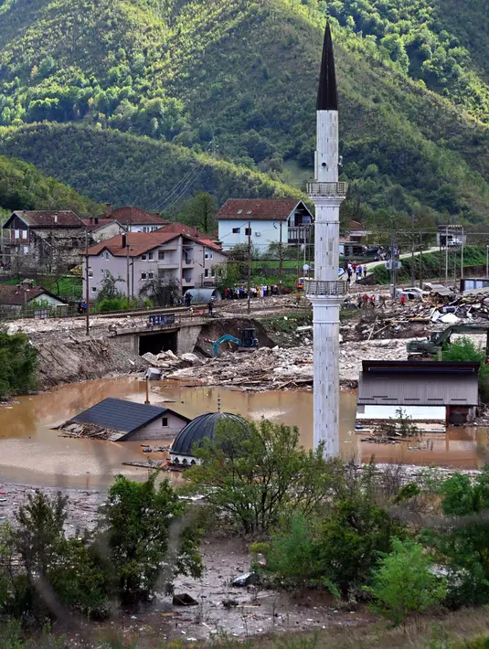 Di wilayah Jablanica, tanah longsor mencapai atap rumah-rumah, sementara sebuah masjid hanya menaranya yang terlihat. (ELVIS BARUKCIC/AFP)