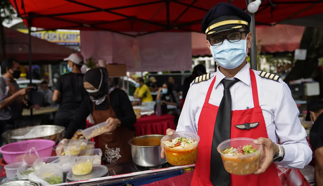 Mantan pilot Azrin Mohamad Zawawi menunjukkan mie laksa kari di warung makannya di Subang Jaya, Malaysia, Rabu (4/11/2020). Kapten Azrin, mantan pilot maskapai Malindo itu bersama 2.200 karyawan lainnya kehilangan pekerjaan usai di-PHK pada akhir Oktober akibat virus corona. (AP Photo/Vincent Thian)