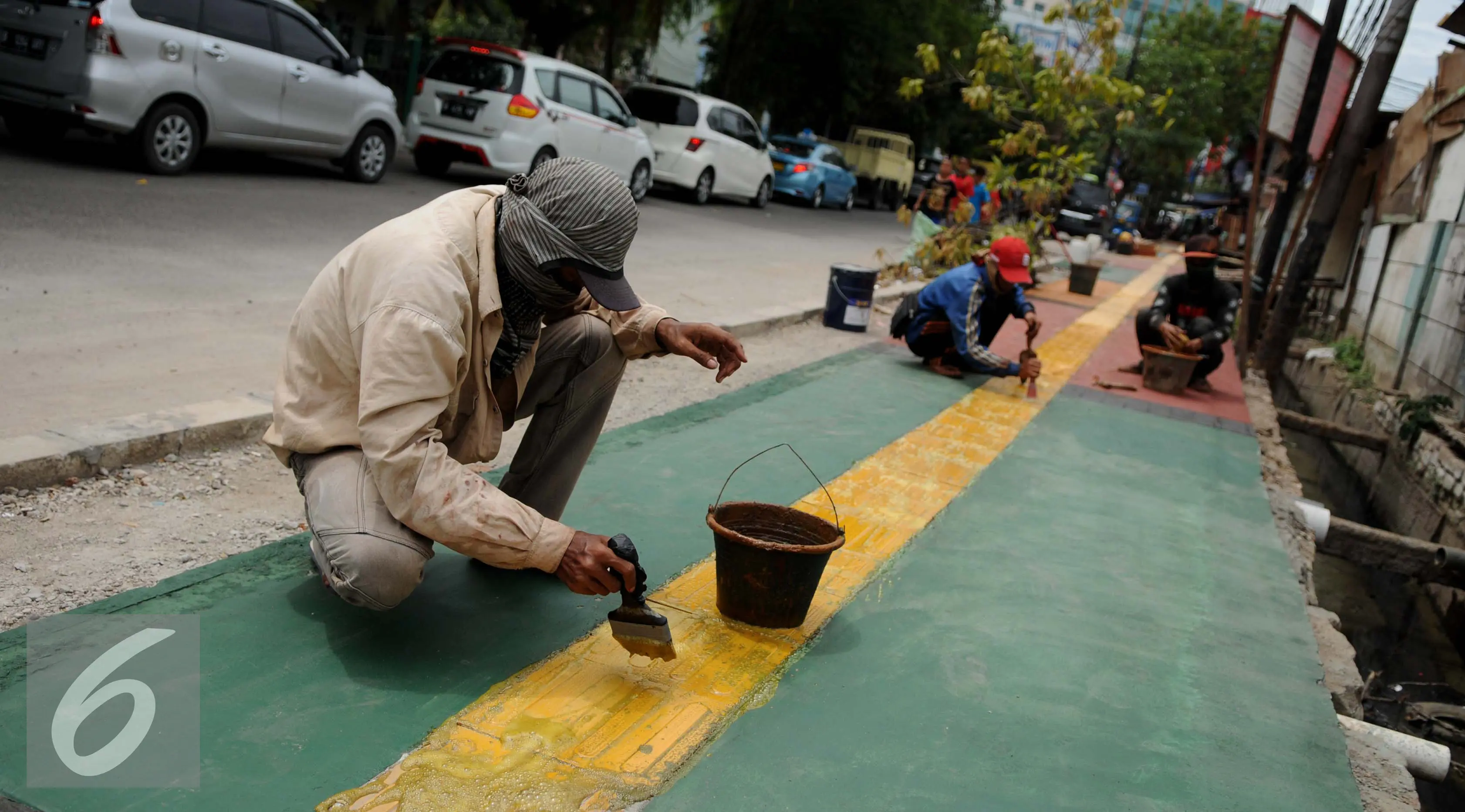 Pekerja menyelesaikan pembangunan Trotoar Ramah Disabilitas di Jalan Hidup Baru, Kalimati, Jakarta Utara, Selasa (27/12). Nantinya trotoar ini akan dibangun sepanjang 753 meter dan lebar 2,4 meter. (Liputan6.com/Gempur M. Surya)
