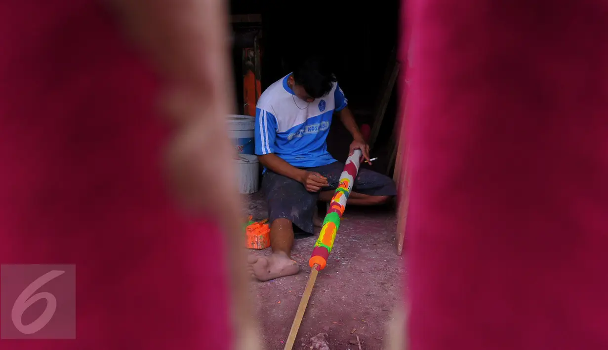 Pekerja sedang mewarnai hio berukuran besar di Teluk Naga, Tangerang, Jumat (15/1/2016). Menjelang perayaan tahun baru Cina (Imlek) pesanan hio melonjak drastis hingga 300 persen. (Liputan6.com/Faisal R Syam)