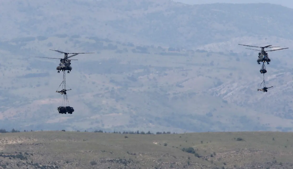 Helikopter Chinook Inggris membawa senjata artileri dan sebuah truk selama latihan militer Swift Response 22 di poligon pelatihan tentara Krivolak, Makedonia Utara, 12 Mei 2022. Latihan militer Swift Response 22 dilakukan untuk menunjukkan kemampuan negara-negara NATO siap ditempatkan di mana saja di seluruh dunia serta tentaranya dapat beroperasi bersama secara profesional dan sukses. (AP Photo/Boris Grdanoski)