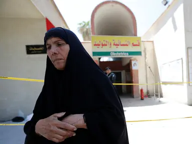 Seorang wanita Irak berdiri di depan bangsal bersalin setelah insiden kebakaran di Rumah Sakit Yarmouk, Baghdad, Rabu (10/8). Kebakaran tersebut menyebabkan 11 bayi prematur yang berada di inkubator tewas. (REUTERS/Thaier Al - Sudani)