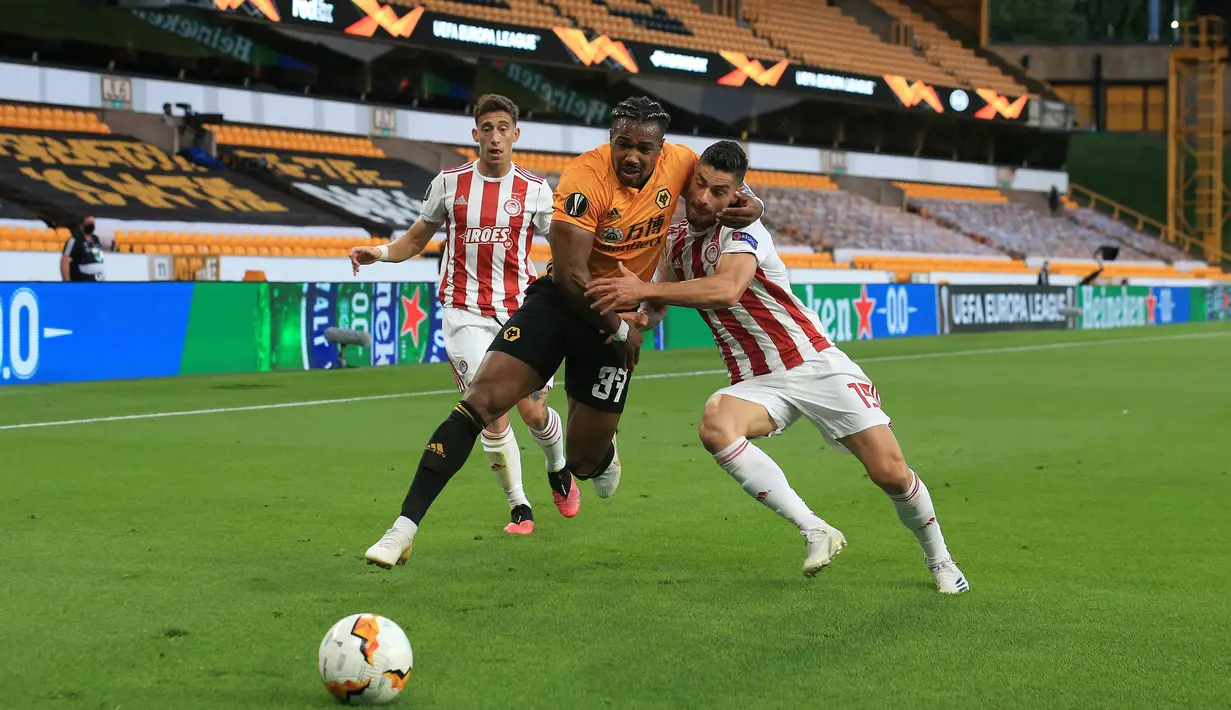 Gelandang Wolverhampton Wanderers, Adama Traore (tengah) berebut bola dengan bek Olympiakos, Svetozar Markovic pada leg kedua babak 16 besar Liga Europa di Molineux Stadium, Kamis (6/8/2020). Wolverhampton menumbangkan Olympiakos dengan skor 1-0. (Lindsey Parnaby/AFP)