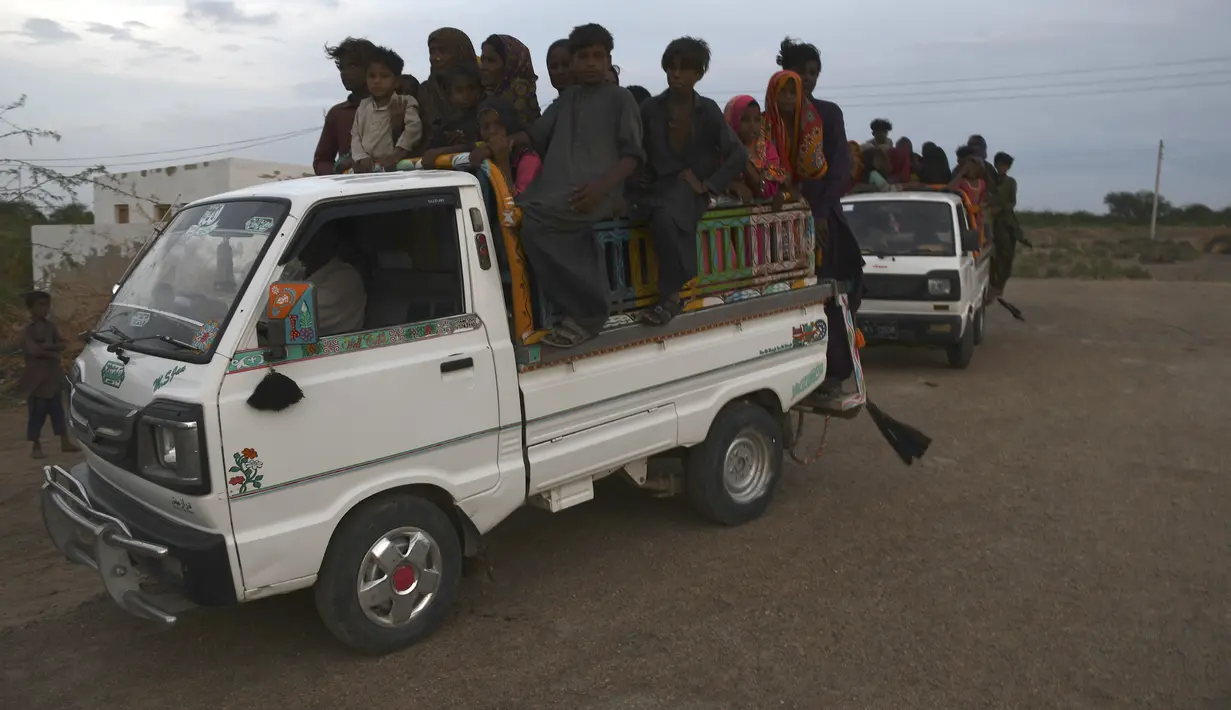 Penduduk setempat bepergian dengan kendaraan saat mereka mengevakuasi daerah tersebut karena Topan Biparjoy mendekat, di daerah pesisir Golarchi di distrik Badin, di provinsi Sindh Pakistan, Selasa, 13 Juni 2023. (AP Photo/Umair Rajput)