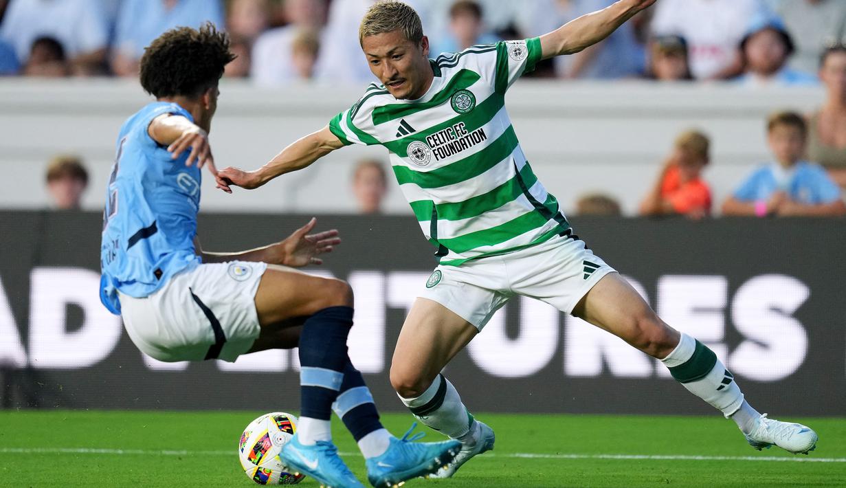 Pemain Glasgow Celtic, Kyogo Furuhashi, berusaha melewati pemain Manchester City, Rico Lewis, pada laga uji coba di Stadion Kenan Memorial, Rabu (24/7/2024). (AFP/Grant Halverson)