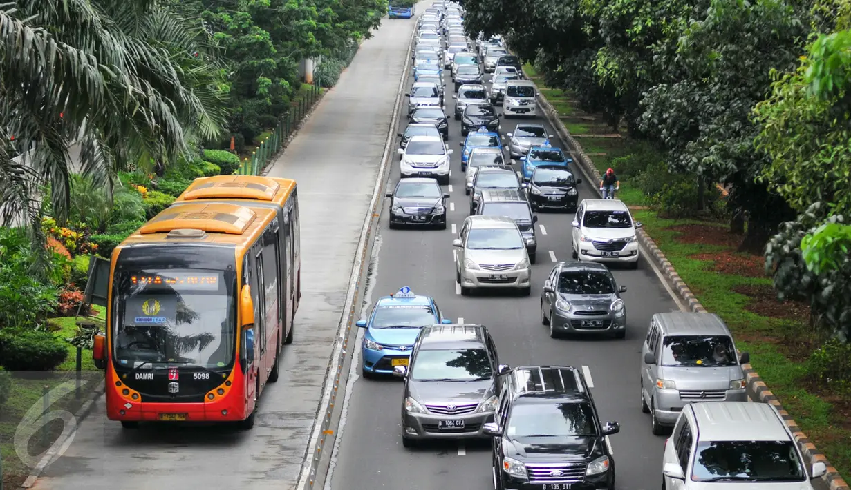 Bus Transjakarta melintas di samping kendaraan yang terjebak kemacetan di kawasan Jenderal Sudirman, Jakarta, Rabu (25/5). Kebijakan Pemerintah menghapus jalur three in one membuat kemacetan di ruas jalan meningkat 24,35 persen (Liputan6.com/Yoppy Renato)