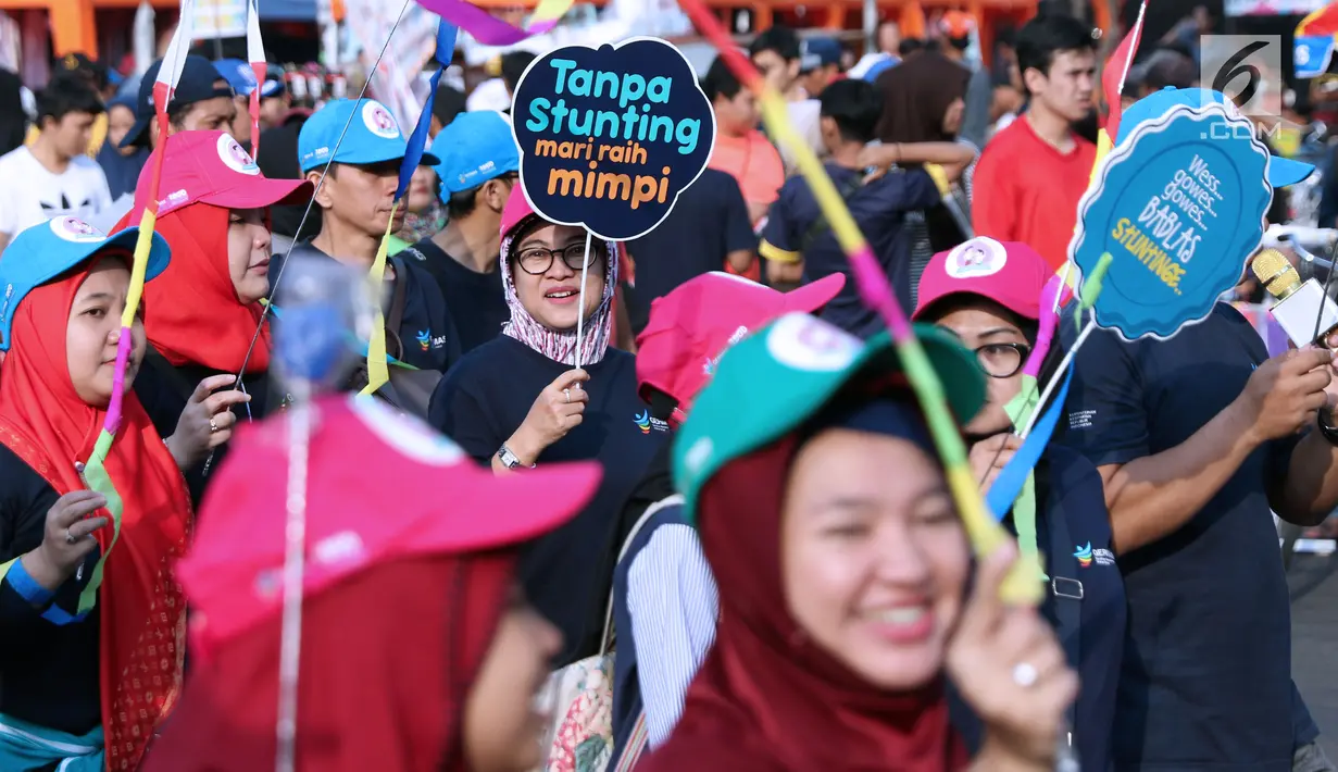 Peserta kampanye cegah stunting membawa tulisan saat berjalan di kawasan Bundaran Hotel Indonesia, Jakarta, Minggu (16/9). Kampanye ini bertujuan mengurangi penderita stunting di Indonesia. (Liputan6.com/Helmi Fithriansyah)