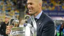 Pelatih Real Madrid Zinedine Zidane memegang trofi usai menjadi juara Liga Champions 2018 di Stadion NSK Olimpiyskiy, Ukraina (26/5). Real Madrid berhasil menjadi juara Liga Champions 2018 usai mengalahkan Liverpool 3-1. (AP/Sergei Grits)