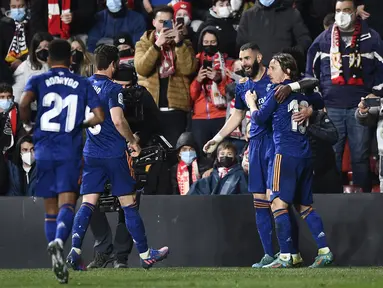 Penyerang Real Madrid, Karim Benzema (kedua kanan) berselebrasi dengan rekan setimnya usai mencetak gol ke gawang Rayo Vallecano pada pertandingan La Liga Spanyol di stadion Vallecas di Madrid, Spanyol, Minggu (27/2/2022). Real Madrid menang tipis atas Rayo Vallecano 1-0. (AP Photo/Jose Breton)