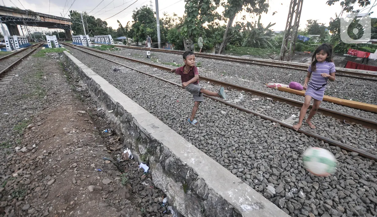 Anak-anak saat bermain di dekat rel kereta api di kawasan Bahari Ujung, Tanjung Priok, Jakarta Utara, Selasa (24/5/2022). Minimnya fasilitas dan ruang terbuka hijau di kawasan tersebut menyebabkan anak-anak setempat memilih bermain di sekitar perlintasan kereta api yang dapat membahayakan keselamatan mereka. (merdeka.com/Iqbal S Nugroho)