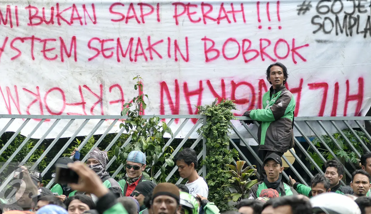 Sebuah spanduk dibentangkan saat massa driver Gojek melakukan aksi protes ke kantor pusat mereka di Kemang, Senin (3/10). Ratusan pengemudi Gojek itu menuntut penghapusan sistem performa atau rating. (Liputan6.com/Yoppy Renato)