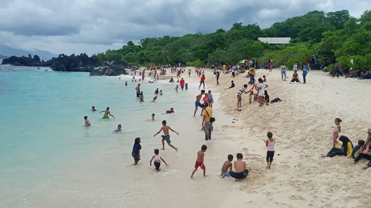 Para wisatawan sedang mandi dan menikmati indahnya pasir putih ina burak. (Liputan6.com/Dionisius Wilibardus)