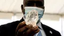 Presiden Botswana Mokgweetsi Masisi memegang berlian permata 1.098 karat di Gaborone, ibu kota Botswana, Rabu (16/6/2021). Permata besar ini hanya sedikit lebih ringan dari berlian terbesar kedua di dunia yang juga ditemukan di Botswana pada tahun 2015. (Monirul Bhuiyan/AFP)