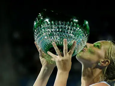 Petenis putri Rusia, Svetlana Kuznetsova, mencium trofi juara turnamen tenis Sydney International setelah di final mengalahkan petenis Puerto Rico, Monica Puig, Minggu (16/1/2016). (Reuters/Jason Reed)