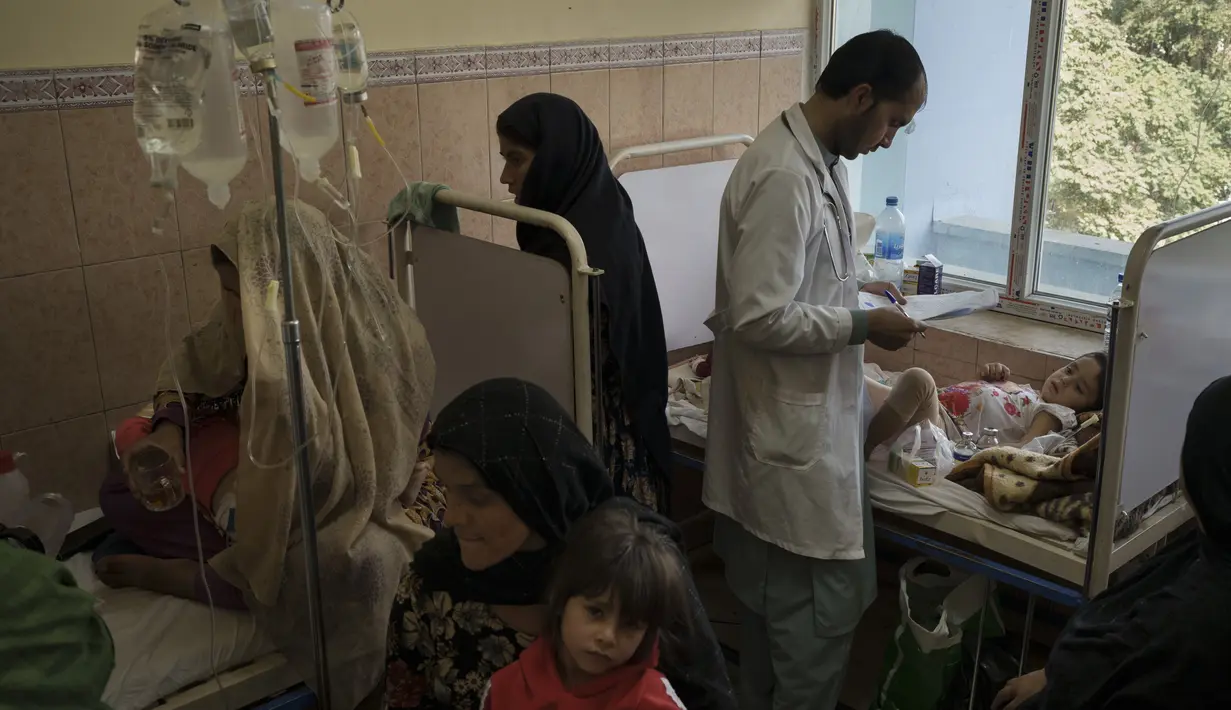 Seorang dokter memeriksa anak perempuan di ruang yang ramai di Rumah Sakit Anak Indira Gandhi di Kabul,  Afghanistan, Selasa (5/10/2021). Petugas kesehatan di rumah sakit itu berlari mondar-mandir merawat bayi prematur dan yang lainnya menderita kekurangan gizi parah. (AP/Felipe Dana)