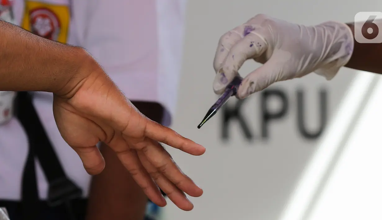 Warga diteteskan tinta di kelingking usai pemungutan suara pada Pilkada Tangerang Selatan di TPS 49 Cendana Residence, Pamulang, Rabu (9/12/2020). TPS 49 pada Pilkada Serentak 2020 mengusung tema Rindu Sekolah Lagi (Kisah-Kasih di Sekolah). (Liputan6.com/Fery Pradolo)