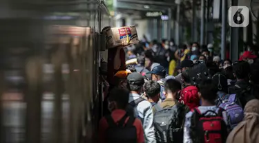 Pemudik menunggu giliran untuk naik ke dalam kereta tujuan mereka di Stasiun Pasar Senen, Jakarta, Selasa (26/4/2022). Sepekan menjelang Lebaran, lonjakan jumlah penumpang kereta api sudah mulai terlihat pada Selasa siang ini, dan diperkirakan akan terus bertambah hingga 30 April atau H-2 Idul Fitri. (Liputan6.com/Faizal Fanani)