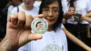 Pendukung Mirna memperlihatkan pin bergambar wajah Mirna yang tengah tersenyum jelang sidang di PN Jakarta Pusat, Kamis (27/10). Sidang ke-32 ini akan memutuskan vonis terkadwa Jessica Kumala Wongso. (Liputan6.com/Helmi Afandi)