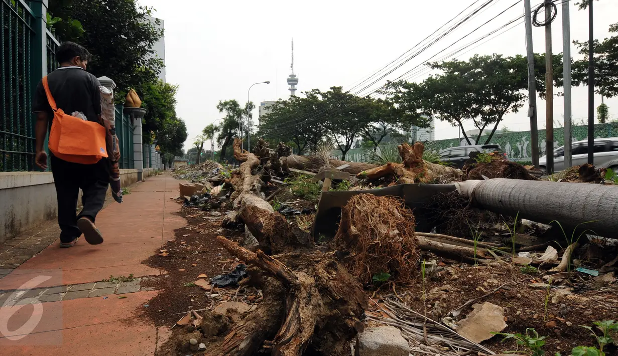 Warga melintasi jalur pedestrian di Jalan Gerbang Pemuda Senayan, Jakarta, Selasa (12/7/2016). Pasca pengosongan lapak pedagang tanaman pertengahan Mei lalu, hingga kini jalur pejalan kaki di kawasan ini masih berantakan. (Liputan6.com/Helmi Fithriansyah)
