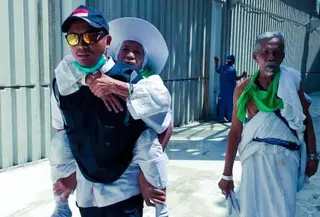 Salah seorang petugas sedang menggendong jemaah calon haji yang kelelahan. (www.kemenag.go.id)