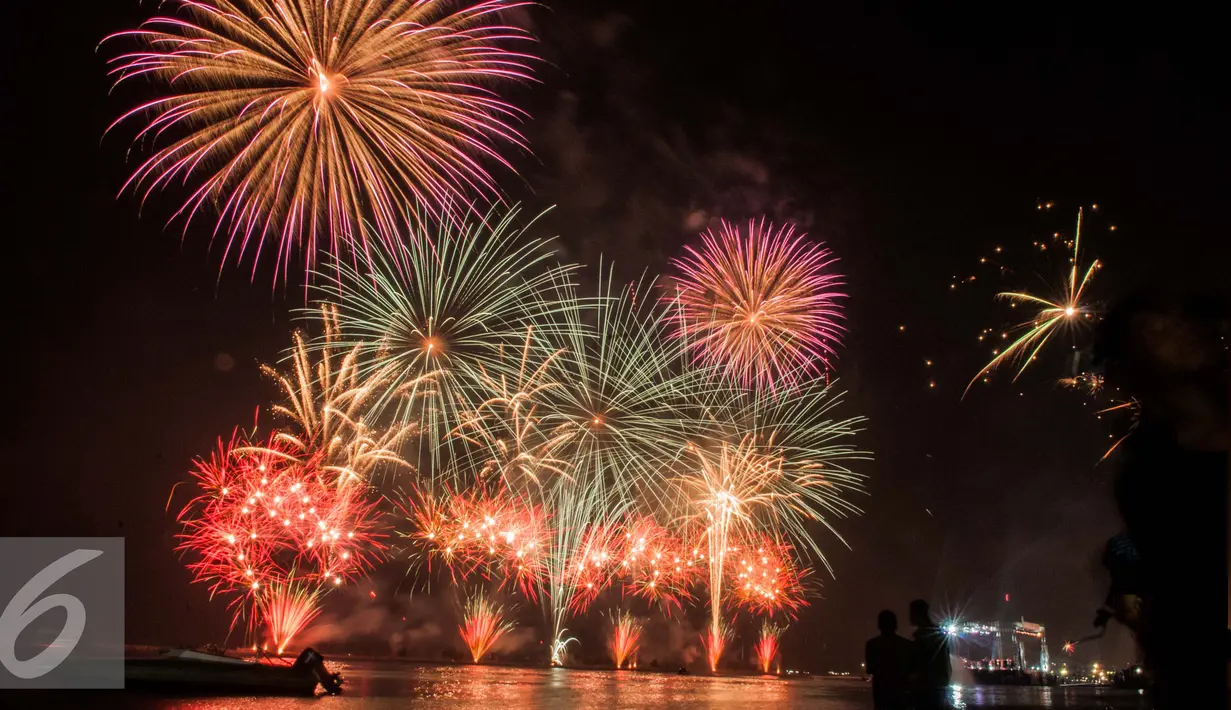 Kembang api menghiasi perayaan malam pergantian tahun di Pantai Lagoon, Ancol, Jakarta (1/1). Warga ibukota memadati kawasan Ancol sebagai pusat perayaan malam pergantian tahun baru dengan menikmati atraksi kembang api. (Liputan6.com/Gempur M. Surya)