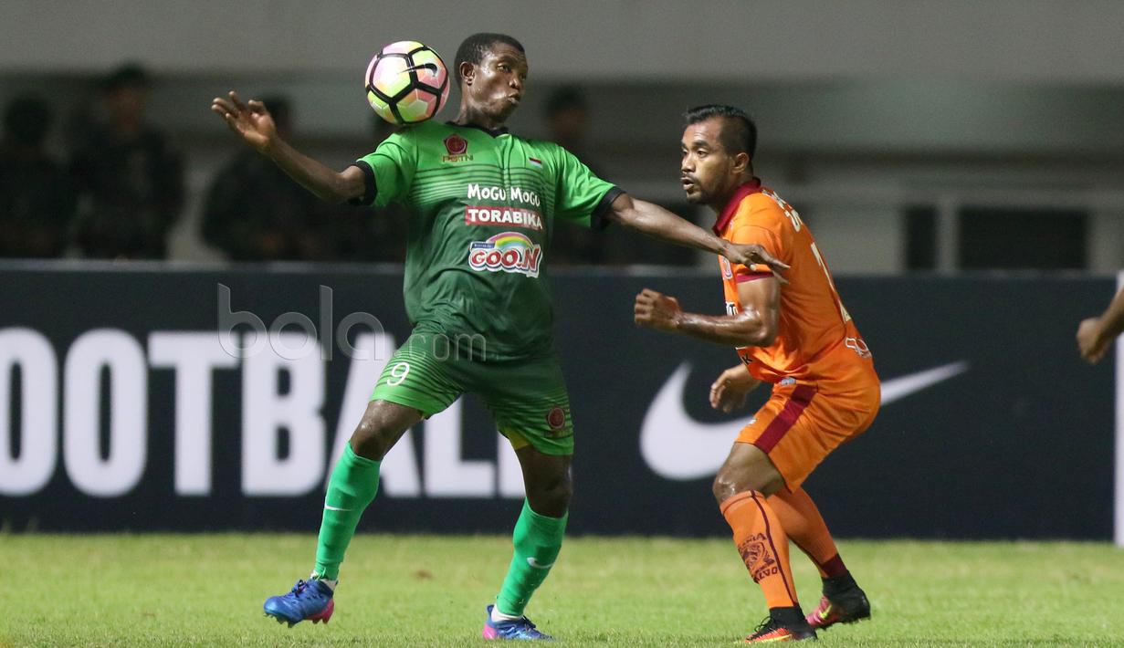 Pemain PS TNI, Aboubacar Sylla (kiri) berduel dengan pemain Borneo FC, Zulvin Zamrun pada lanjutan Liga 1 2017 di Stadion Pakansari, Bogor, Senin (17/4/2017). PS TNI dan Borneo FC bermain imbang 2-2. (Bola.com/Nicklas Hanoatubun)