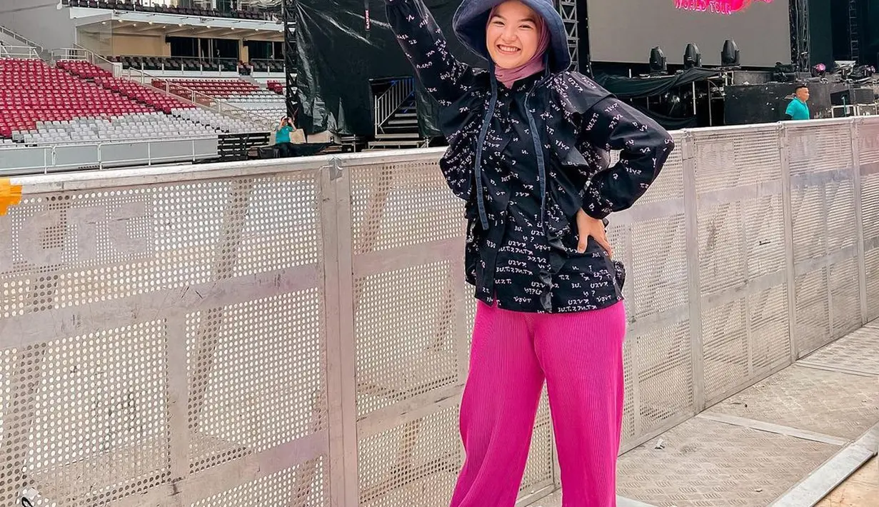 Marsha Natika tampil sporty dengan hoodie hitam dan celana pink. Penampilannya dilengkapi dengan hijab pink dan topi hitam yang menambah vibe festival. [@marshanatika]