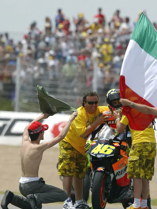 Sejumlah fans dari pebalap MotoGP, Valentino Rossi, memasuki lintasan balap untuk menghampiri idolanya saat GP Spanyol di Sirkuit Jerez, Spanyol, Minggu (11/5/2003). (AFP/Pierre-Philippe Marcou)