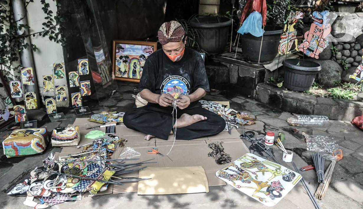 Seniman Iskandar Hardjodimuljo menyelesaikan pembuatan wayang uwuh di kawasan Cawang, Jakarta, Kamis (29/10/2020). Wayang uwuh dicetus oleh ayah dua anak ini pada 2013. (merdeka.com/Iqbal S. Nugroho)