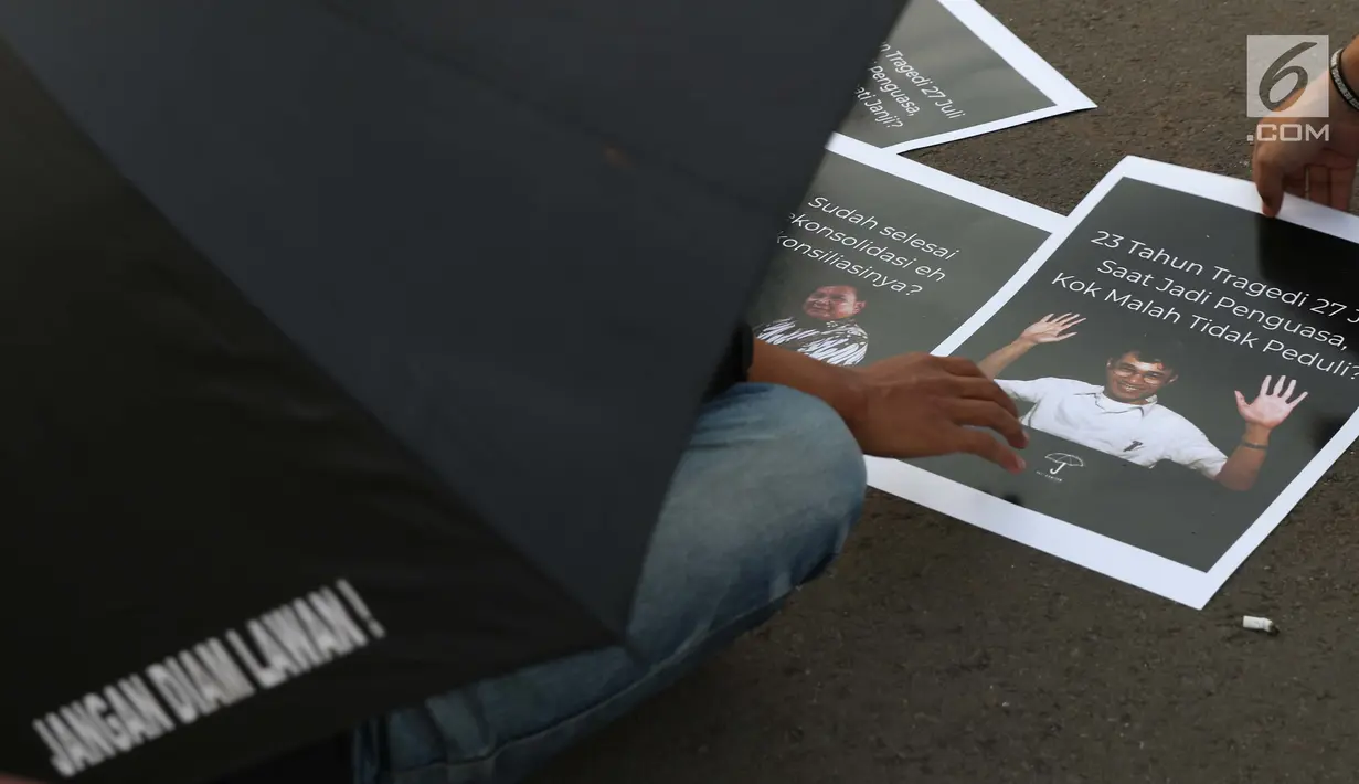 Aktivis yang tergabung dalam Jaringan Solidaritas Korban untuk Keadilan mengambil poster saat aksi Kamisan di depan Istana Negara, Jakarta, Kamis (25/7/2019). Aksi Kamisan ke-594 mengangkat tema '23 Tahun Tragedi 27 Juli Saat Jadi Penguasa Kok Malah Tidak Peduli?'. (Liputan6.com/Helmi Fithriansyah)