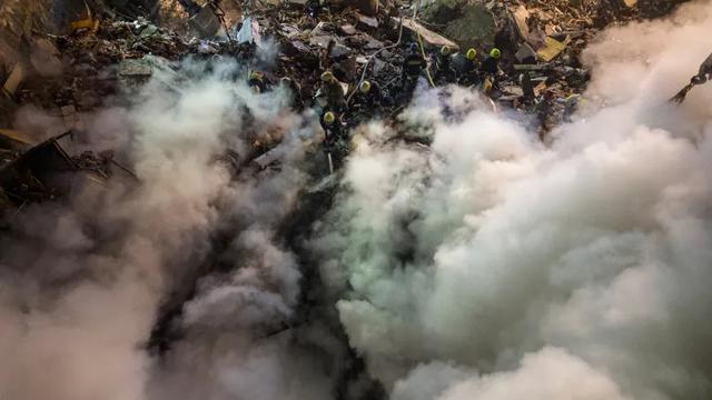 Pekerja darurat membersihkan puing-puing setelah roket Rusia menghantam gedung bertingkat, meninggalkan banyak orang di bawah puing-puing di tenggara Kota Dnipro, Ukraina [Evgeniy Maloletka/AP Photo]