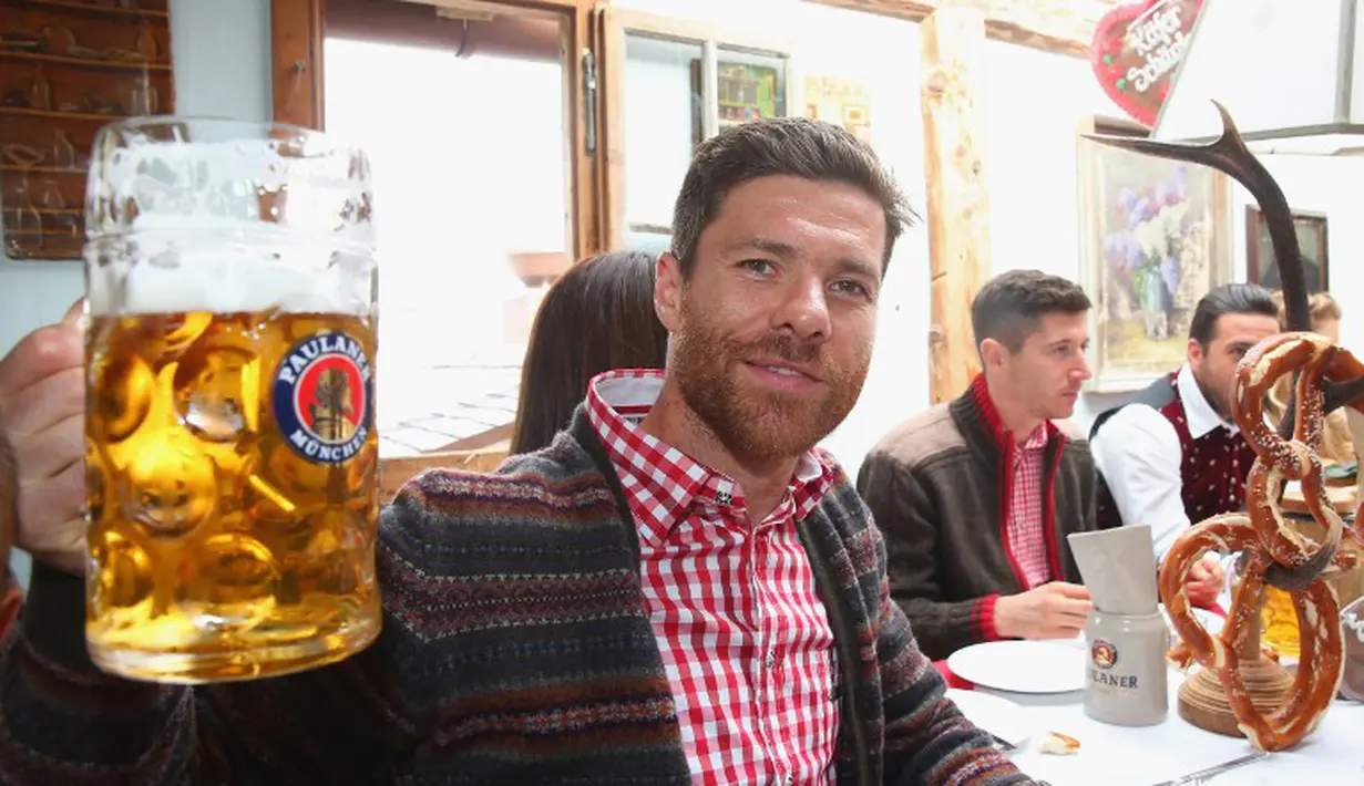 Xabi Alonso memperlihatkan gelas birnya saat di acara Oktoberfest, Jerman, Minggu (5/10/2014)(AFP PHOTO/ALEXANDRA BEIER)