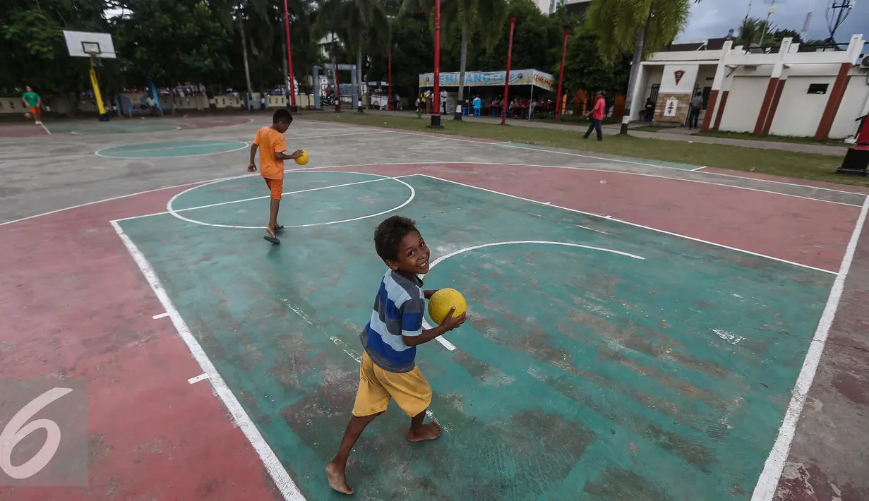 Dua orang bocah bermain bola di Lapangan Merdeka, Ambon, Maluku, Senin (7/2). Saat sore tiba banyak masyarakat Ambon mendatangin Lapangan untuk bersantai atau pun berolahraga. (Liputan6.com/Faizal Fanani)