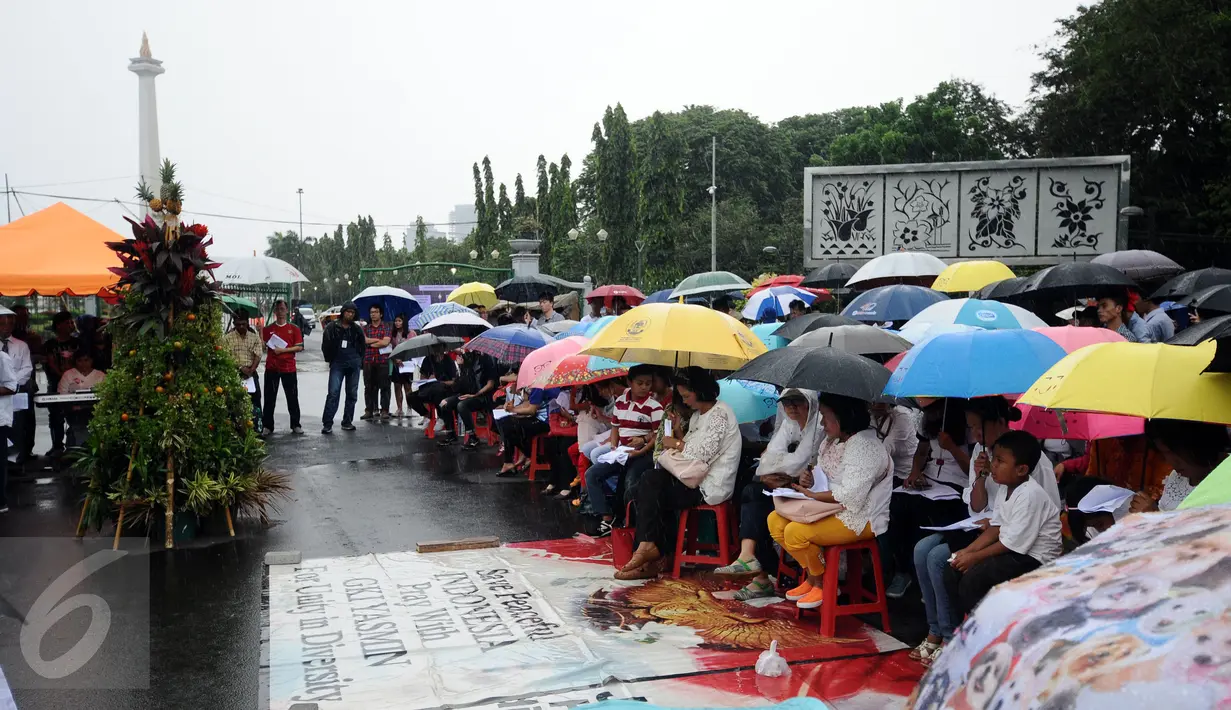 Jemaat GKI Yasmin Bogor dan HKBP Filadelfia Bekasi melakukan misa perayaan Natal 2016 di Silang Barat Laut Monas, Jakarta, Minggu (25/12). Mereka berharap pemerintah turun tangan karena gereja mereka masih disegel. (Liputan6.com/Helmi Fithriansyah)