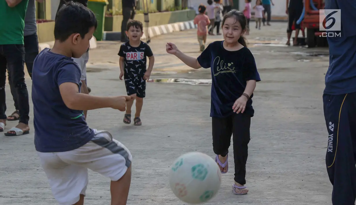 Anak-anak pencari suaka bermain sepak bola di halaman bekas Markas Kodim di Kalideres, Jakarta, Selasa (16/7/2019). Sebelumnya, para pencari suaka dari berbagai negara berkonfilk ini tinggal di pinggir jalan dan trotoar di kawasan Kebon Sirih, Jakarta. (Liputan6.com/Helmi Fithriansyah)