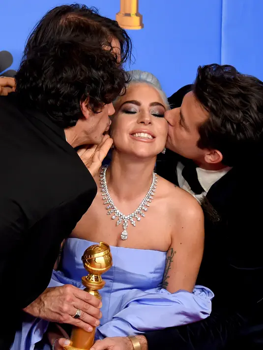Lady Gaga dicium Mark Ronson, Andrew Wyatt, dan Anthony Rossomando usai memenangkan piala penghargaan Golden Globes 2019 di The Beverly Hilton, Beverly Hills, California, Minggu (6/1). (Photo by Jordan Strauss/Invision/AP)