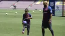Pemain baru Barcelona, Arturo Vidal, bersama anaknya Alonso, saat perkenalan di Stadion Camp Nou, Senin, (7/8/2018). Barcelona merogoh kocek sebesar 19 juta euro untuk mengamankan jasa pria berkebangsaan Cile itu. (AFP/Josep Lago)