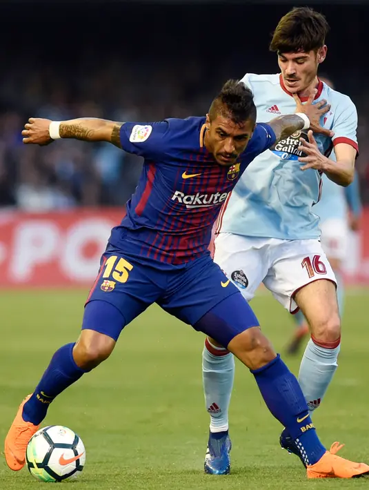 Pemain Barcelona Paulinho berebut bola dengan gelandang Celta Vigo Jozabed Sanchez pada laga pekan ke-33 La Liga di Estadio de Balaidos, Selasa (17/4). Barcelona gagal meraih poin penuh usai bermain imbang 2-2 melawan Celta Vigo. (MIGUEL RIOPA / AFP)