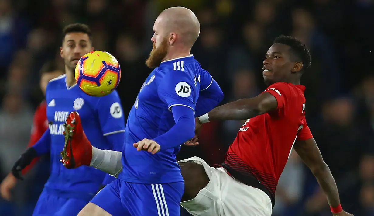 Gelandang Manchester United, Paul Pogba, berusaha melewati gelandang Cardiff, Aron Gunnarsson, pada laga Premier League di Stadion Cardiff City, Wales, Sabtu (22/12). Cardiff kalah 1-5 dari MU. (AFP/Geoff Caddick)