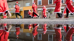 Peserta berkostum Santa Claus ambil bagian dalam kegiatan amal Santa Claus Run di Michendorf, Jerman timur, Minggu (10/12). Kegiatan yang menjadi tradisi umat Kristiani ini diikuti mulai dari orang tua, hingga anak-anak. (Ralf Hirschberger / dpa / AFP)