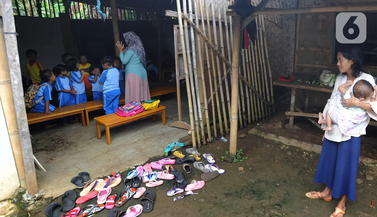 Seorang ibu melihat aktivitas belajar mengajar di Pendidikan Usia Dini (PAUD) Pelopor di Desa Cibeuteung, Ciseeng, Bogor, Rabu (19/2/2020). Sudah sejak 2009, PAUD yang memiliki 30 murid ini belajar pada bangunan sederhana menumpang di tanah milik orang lain. (merdeka.com/Arie Basuki)