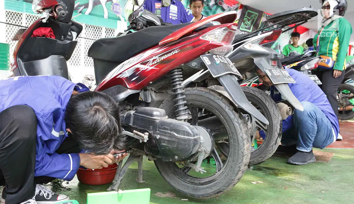 Montir menservis dan ganti oli motor milik buruh secara gratis di Lapangan Ahmad Yani, Tangerang, banten (1/5). Lebih 500 sepeda motor medapatkan servis dan ganti oli secara gratis oleh Serikat Pekerja Seleruh Indonesia. (Merdeka.com/Arie Basuki)