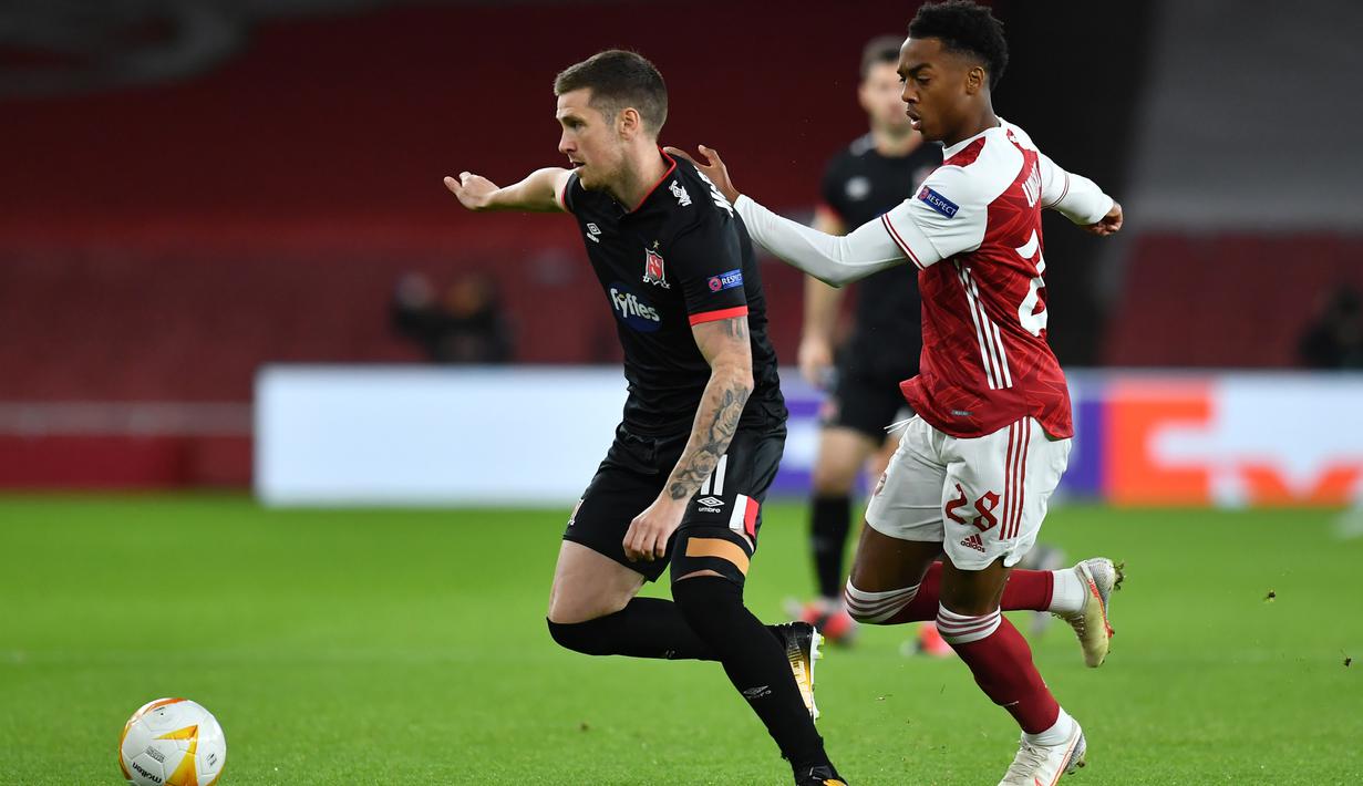 Gelandang Arsenal, Joe Willock, berebut bola dengan bek Dundalk, Daniel Cleary. pada laga lanjutan Liga Europa 2020/2021 di Emirates Stadium, Jumat (30/10/2020) dini hari WIB. Arsenal menang 3-0 atas Dundalk. (AFP/Glyn Kirk)