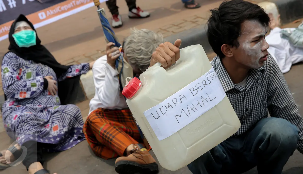 Massa dari Aksi Cepat Tanggap (ACT) melakukan teatrikal saat aksi menolak asap di Patung Kuda, Jakarta, Senin (26/10). Aksi itu menuntut elemen masyarakat agar terlibat langsung dalam upaya penuntasan masalah asap. (Liputan6.com/Faizal Fanani)