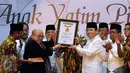 Ketua Umum Partai Golkar, Setya Novanto (kedua kanan) mengangkat penghargaan dari MURI jelang buka puasa AMPG bersama ribuan anak yatim piatu di Jakarta, Sabtu (18/6). Acara diikuti sekitar 26 ribu anak yatim piatu. (Liputan6.com/Helmi Fithriansyah)